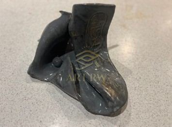 Abstract metal sculpture combines organic, fluid artistic style with flowing curved lines and a textured surface.